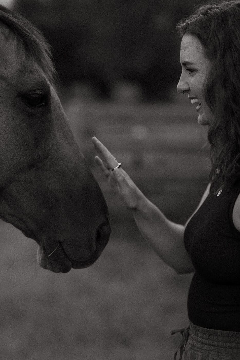 A woman pets a horse