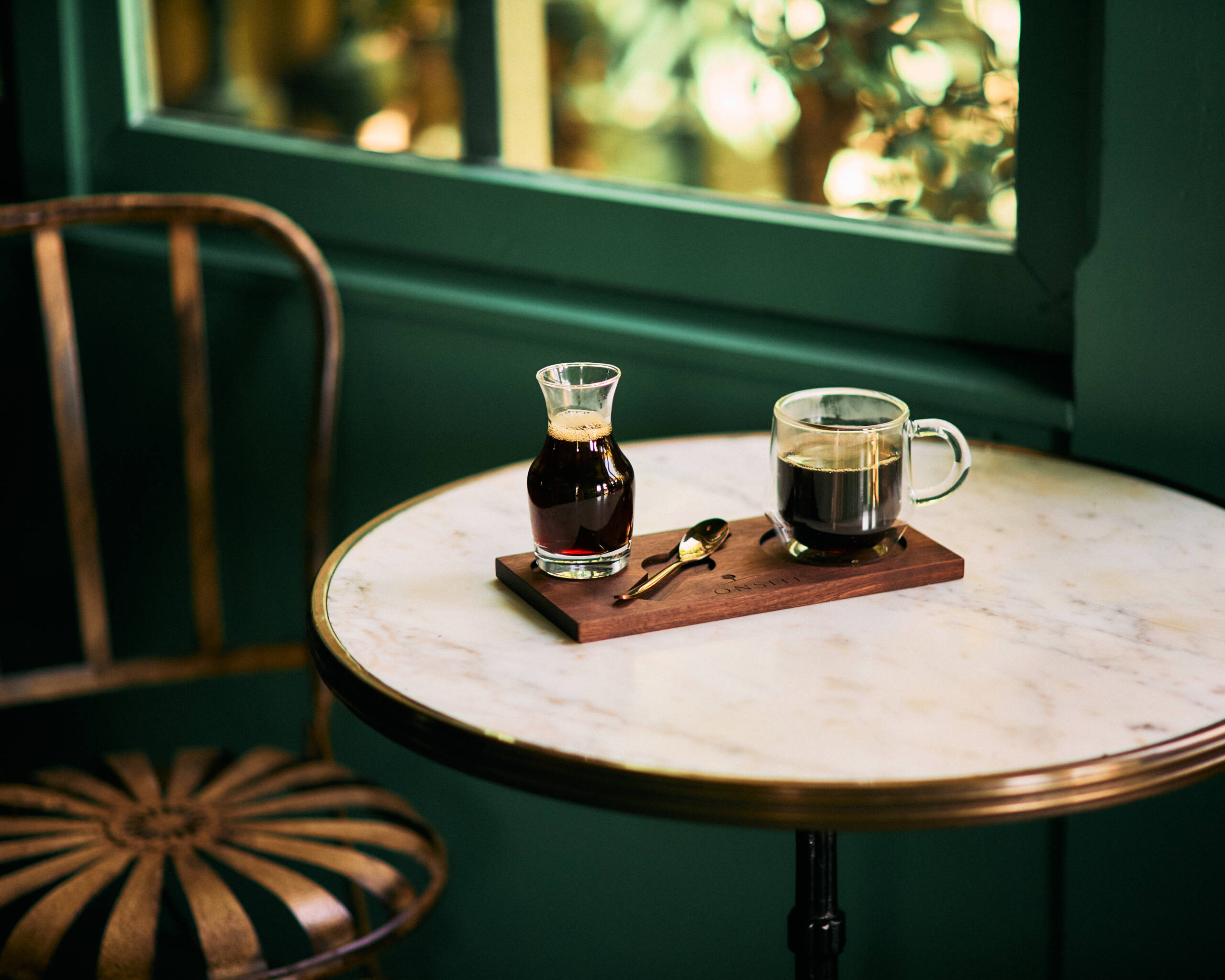 A closeup shot of a small table and chair near a window