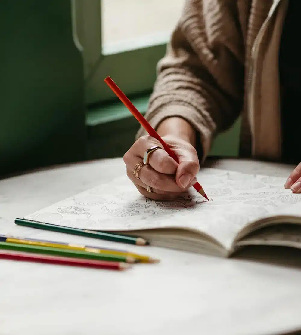 cropped photo of a person drawing in a notebook